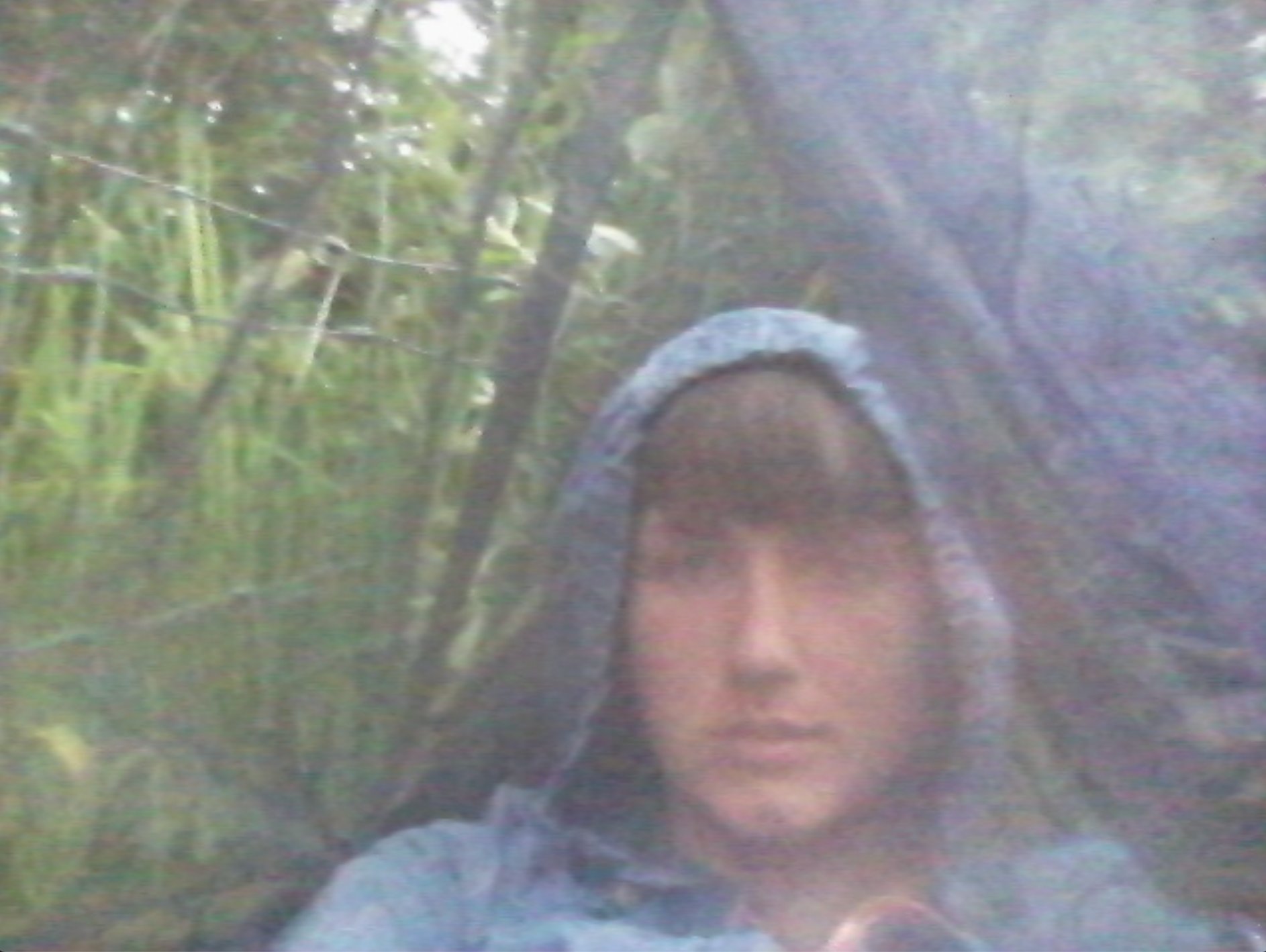 Bethany in blue jacket inside hammock, Washington coast, stealth camping